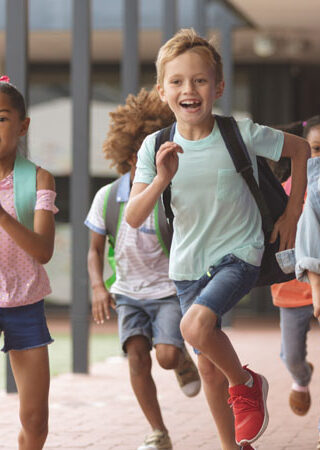 Front,View,Of,Happy,Diverse,School,Kids,Running,In,Corridor