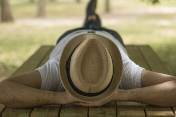 Restful,Young,Man,Wearing,A,Straw,Hat,Laying,Down,On